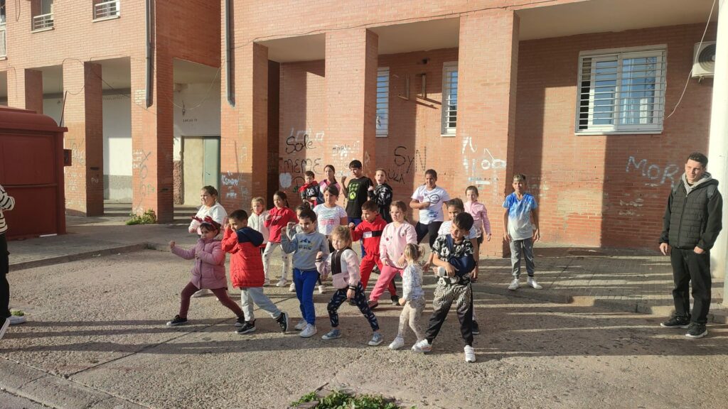 Group of kids dancing outside in Las Palmeras neighbourhood.