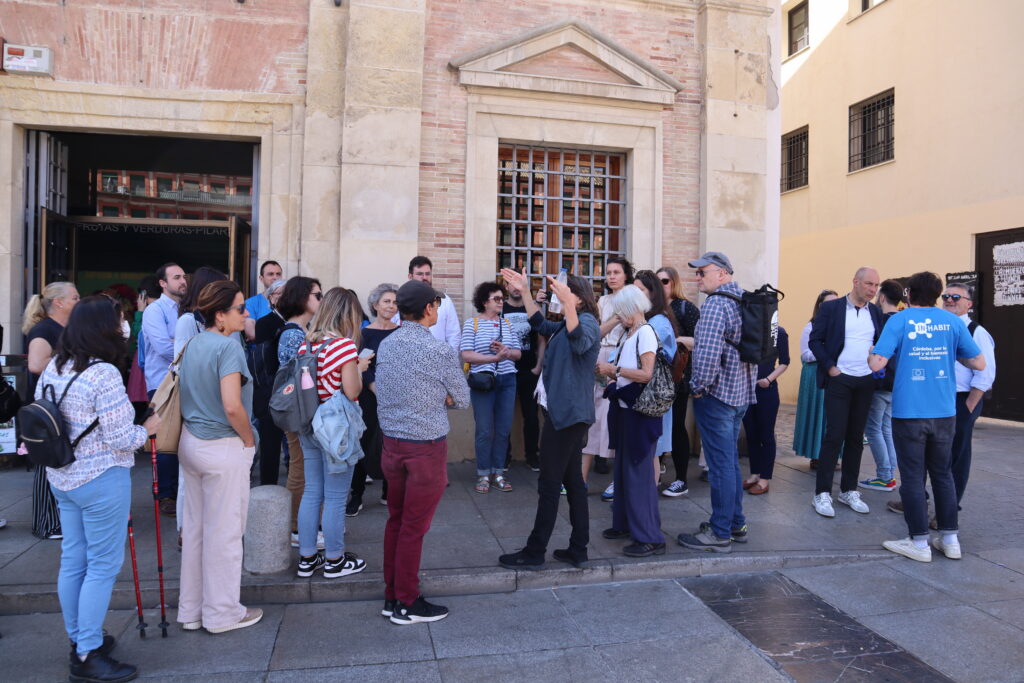 Group of people congregates in front of a historic building in Cordoba